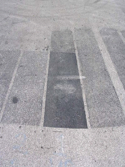 Test strips of polymer modified asphalt-based pavement sealer and refined coal tar-based pavement sealer February 2010. Note that the refined tar-based sealer is still present while the asphalt based product had almost completely worn off